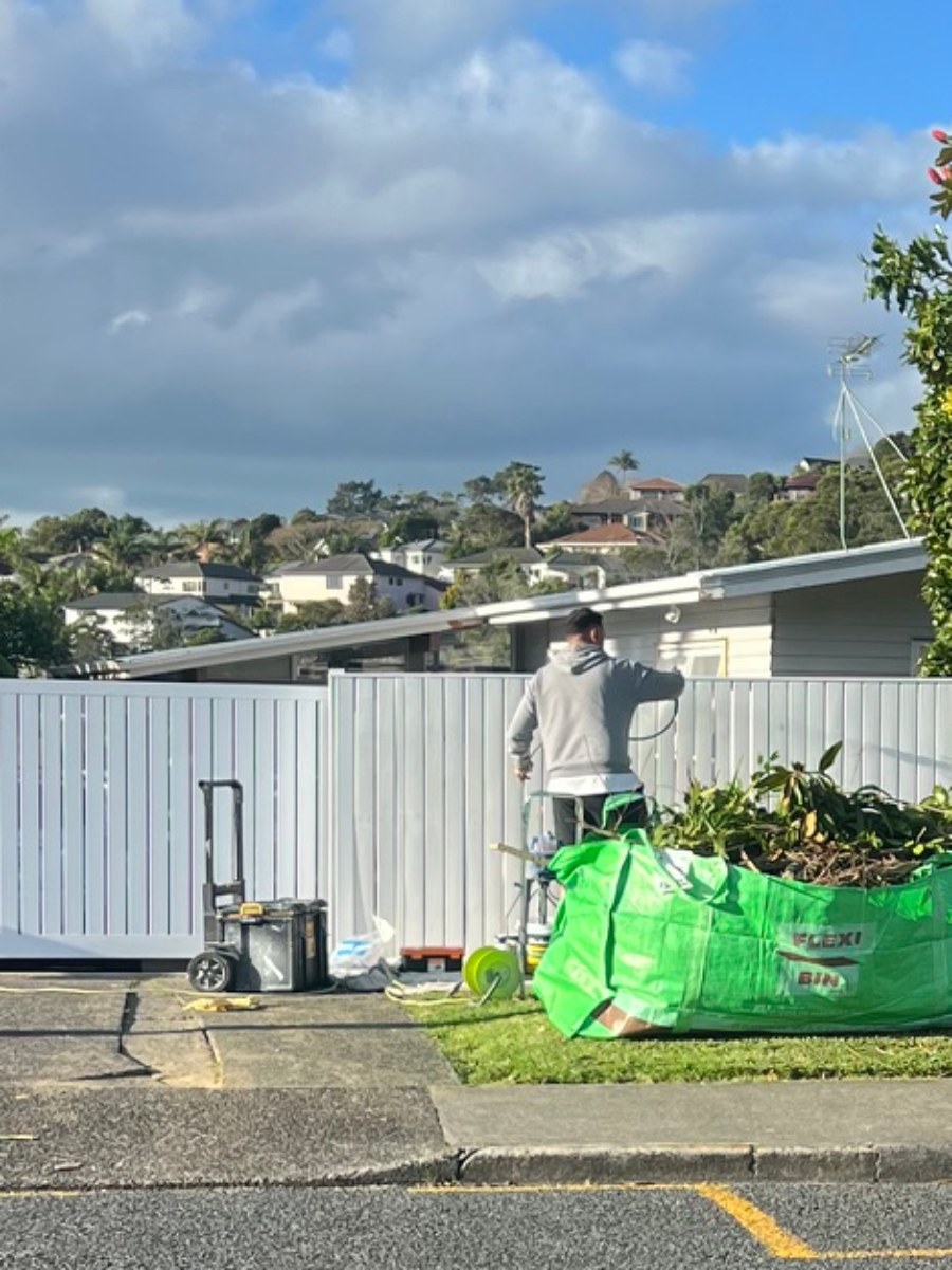 A2D painter spraying a freshly painted fence